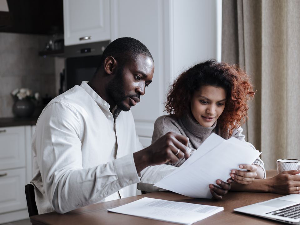 Un couple relit un contrat à la table de la cuisine