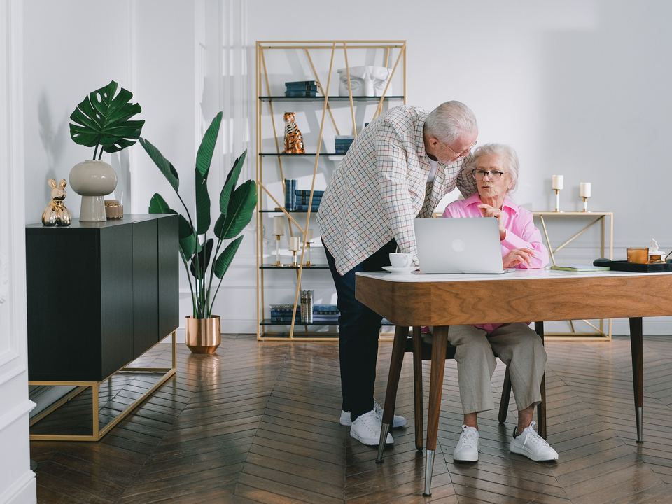 Un couple âgé à son bureau, dans un salon lumineux