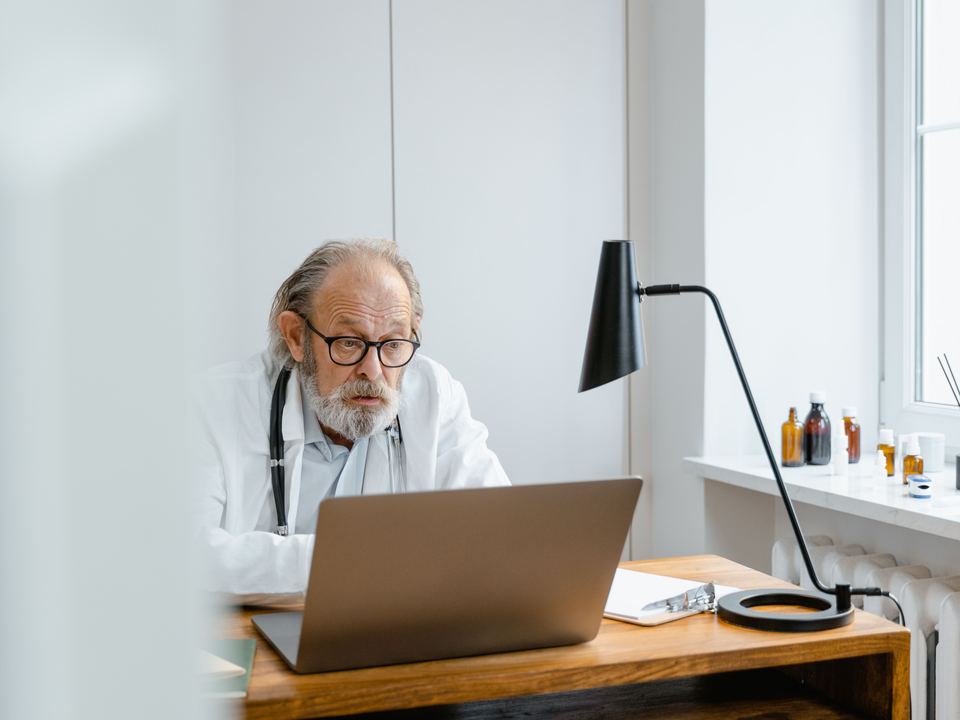 Un médecin à son bureau devant son ordinateur
