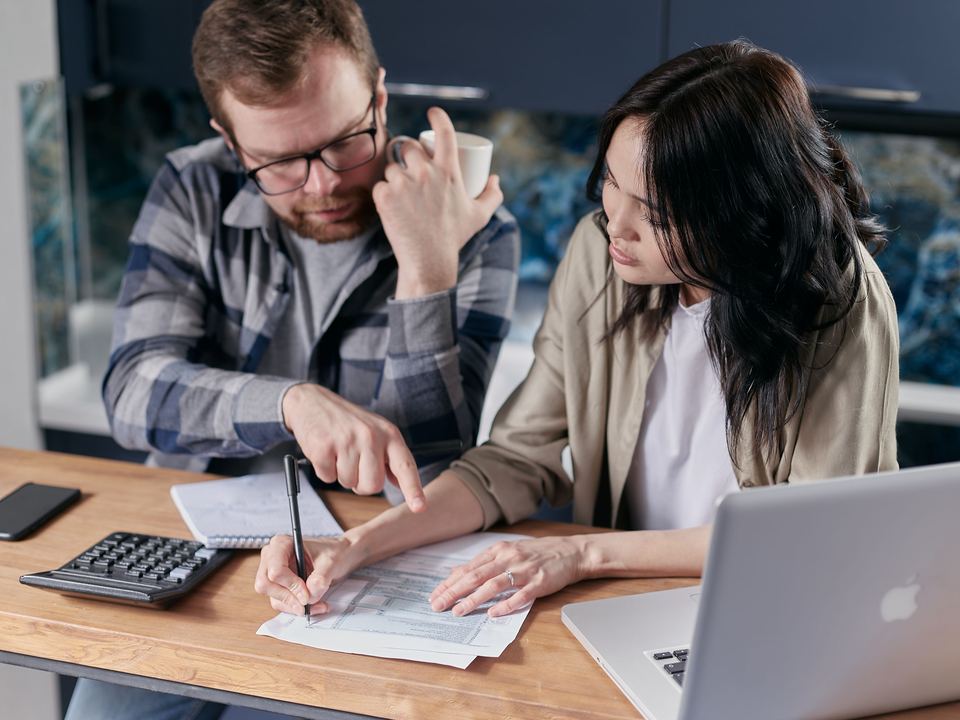 Un couple fait ses comptes avec une calculatrice