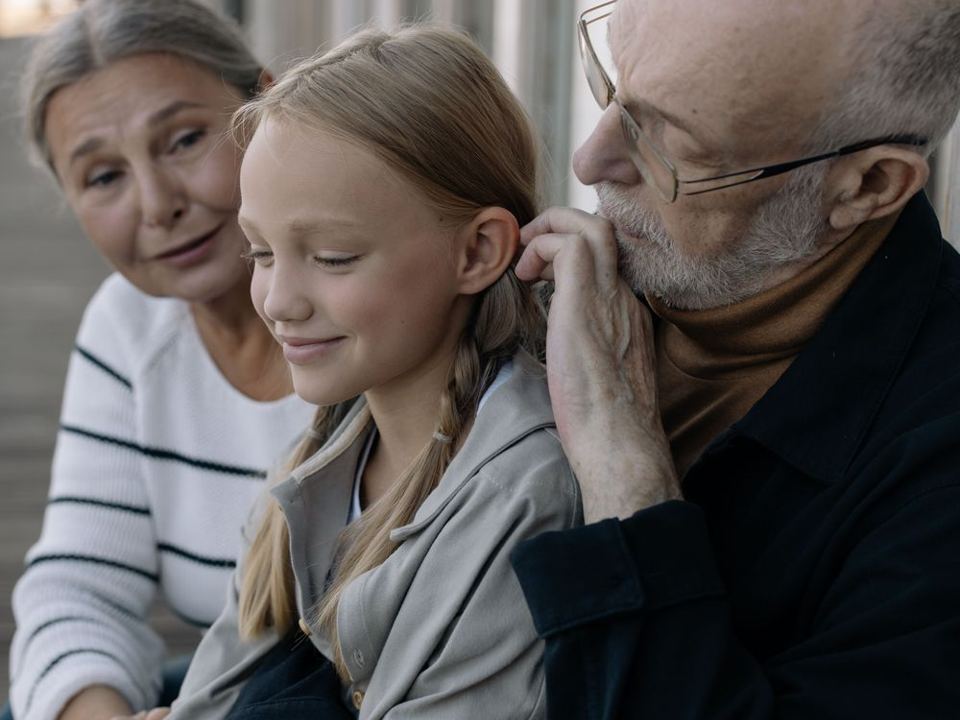 Des grands-parents assis avec leur petite-fille