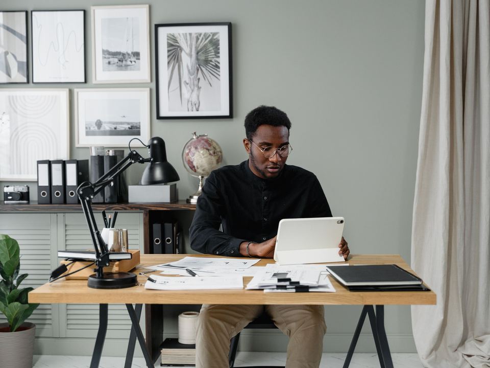 Un homme travaille sur sa tablette à son bureau