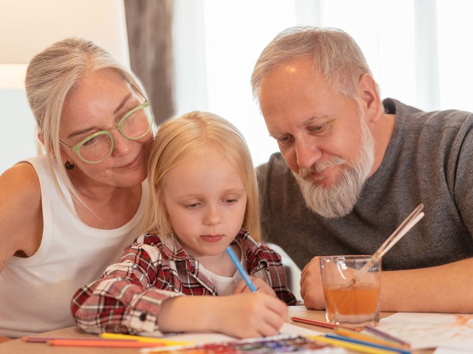 Des grands-parents dessinent avec leur petite-fille