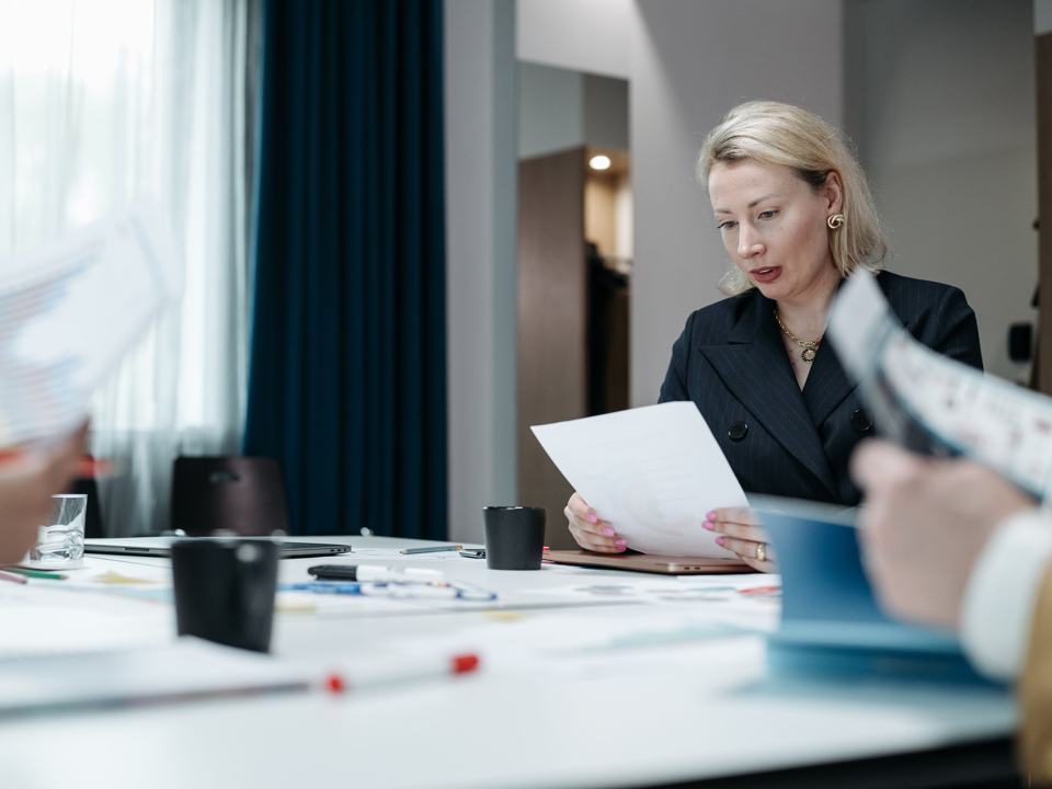 Une dirigeante relit des documents en réunion