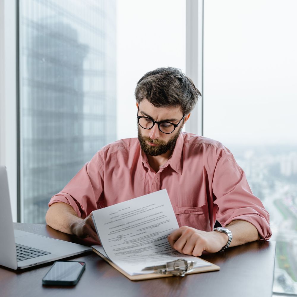 Un homme relit des documents à son bureau